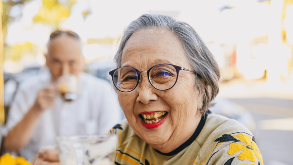Seniorin sitzt in einem Café und lacht – Silver Society  