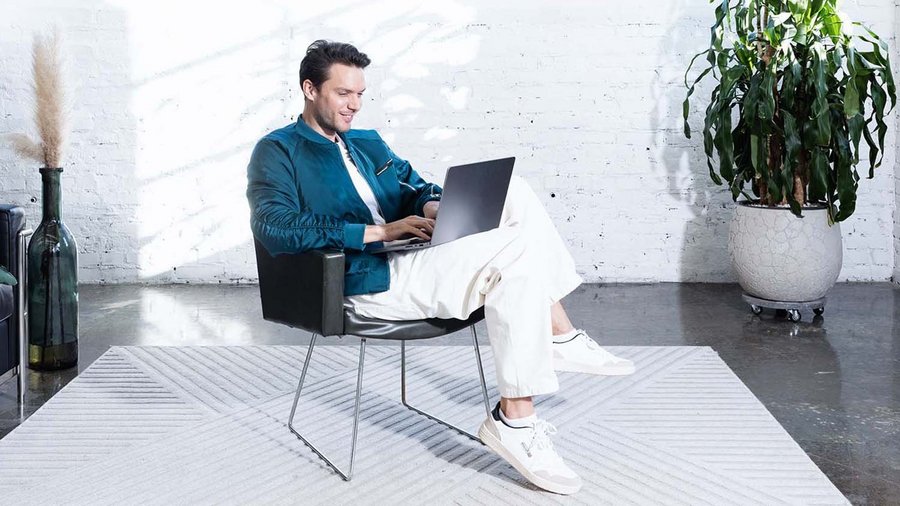 Junger Mann arbeitet am Laptop und plant sein Budget.