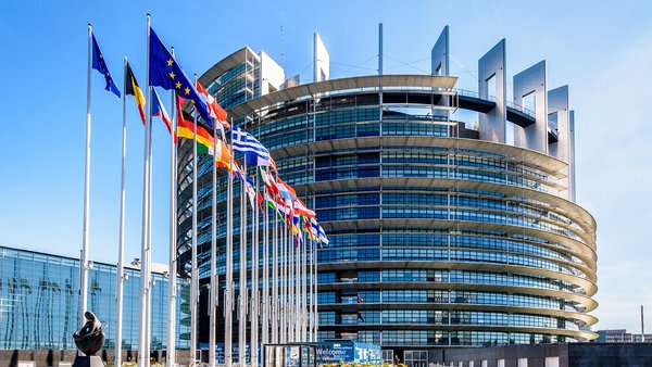 Glass building with European flags in front