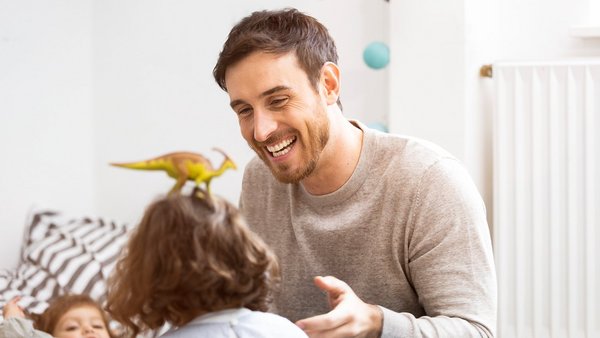 Father plays with his children during parental leave