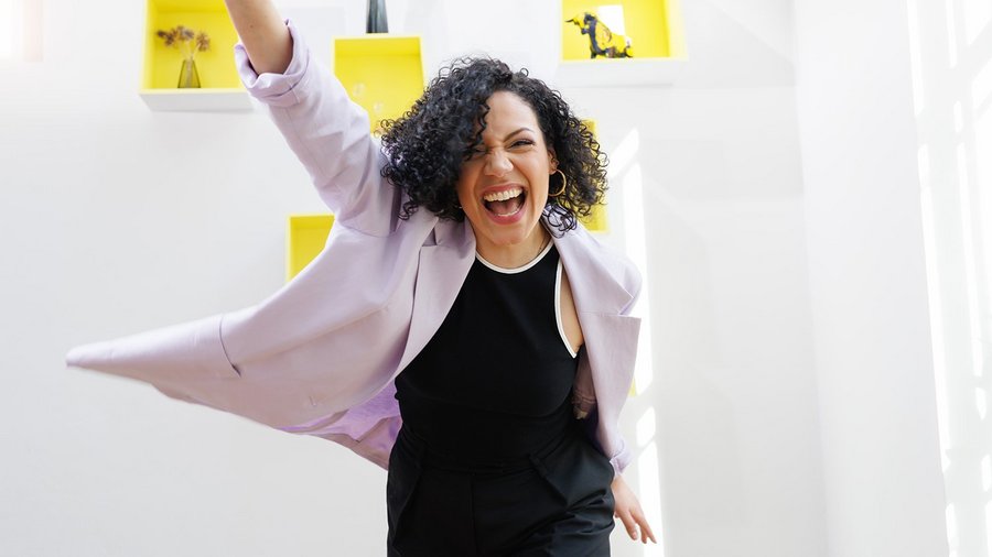 Woman raises her arm in the air laughing and motivating her team
