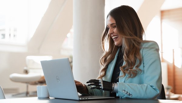 Lachende Frau beim digitalen Netzwerken am Laptop
