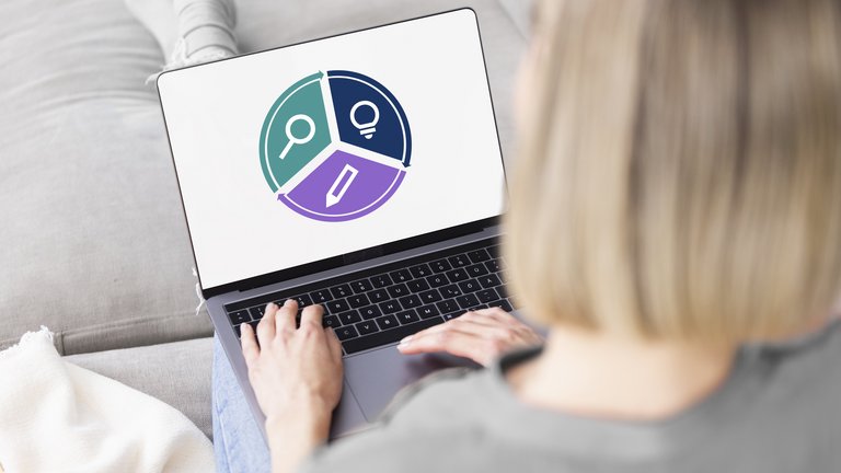 Woman holding a laptop on her lap and looking at the advisory circle symbol on her laptop