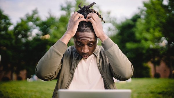 Man slaps hands over head in front of notebook - Error culture