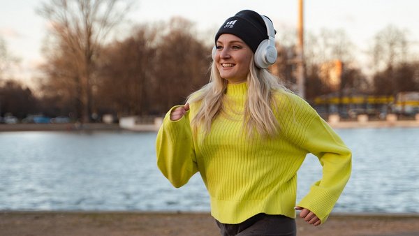 Frau joggt mit Kopfhörern – Fit am Arbeitsplatz Frau joggt mit Kopfhörern – Fit am Arbeitsplatz