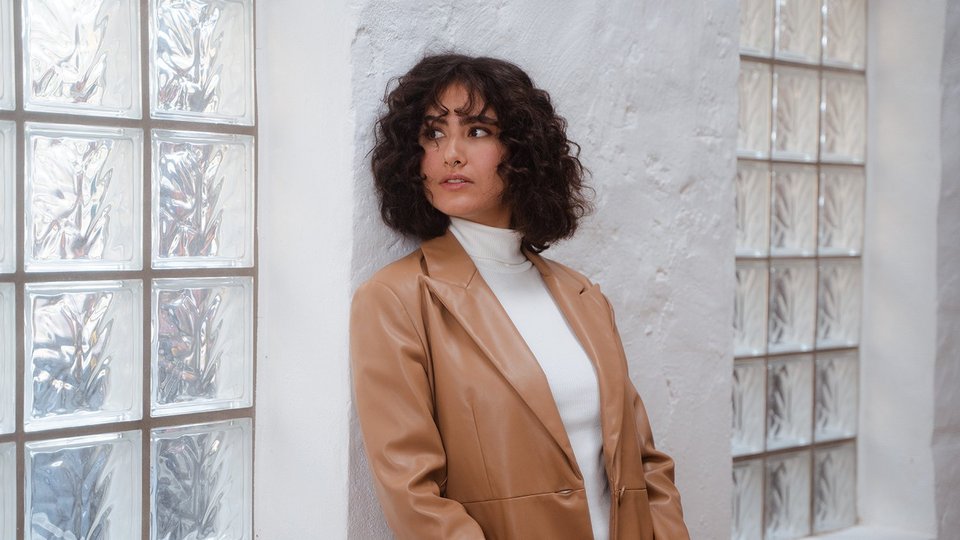 Young woman leaning against the wall and thinking about a career change