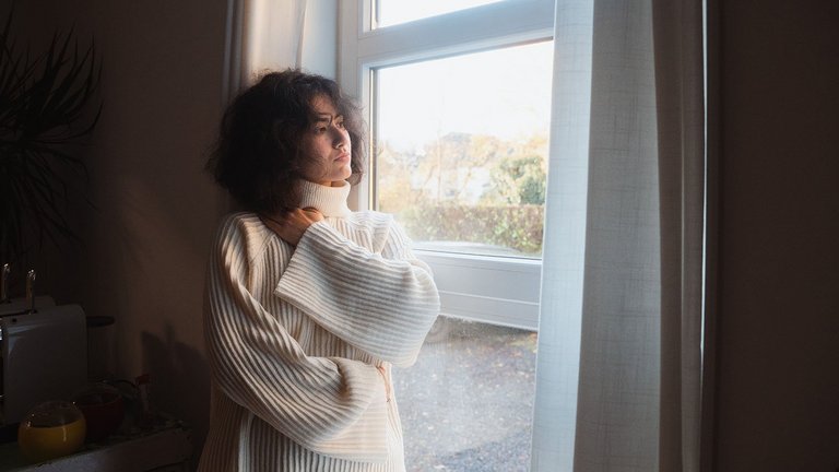 Frau guckt aus dem Fenster