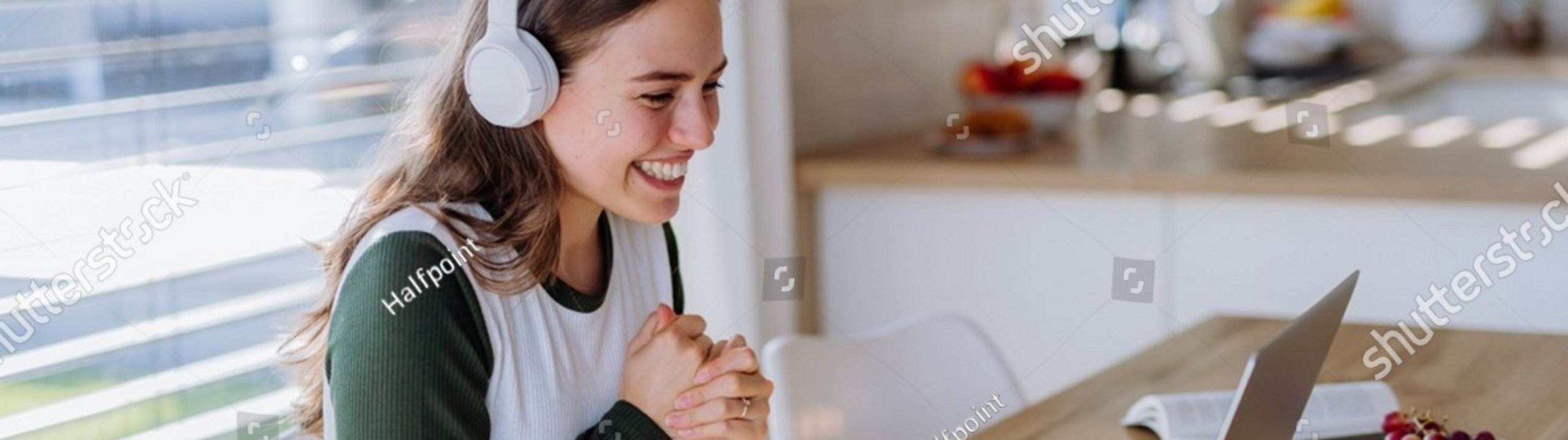 Lächelnde Frau am Laptop mit Kopfhörern