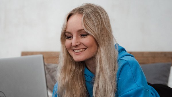 Junge Mutter am Laptop plant den Wiedereinstieg nach der Elternzeit