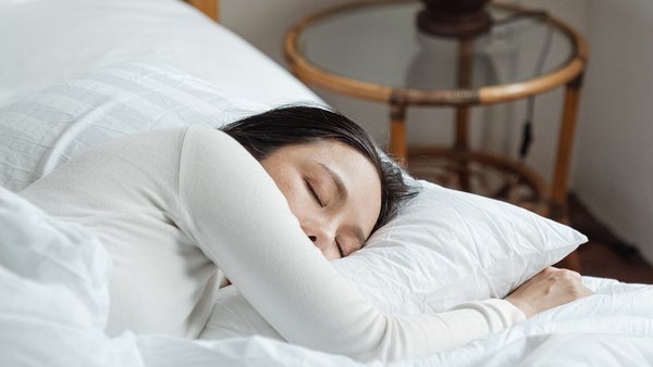 Frau schläft im Bett – Mentale Gesundheit im Job 