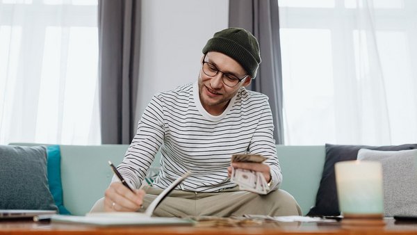 A man sits at a table and counts money