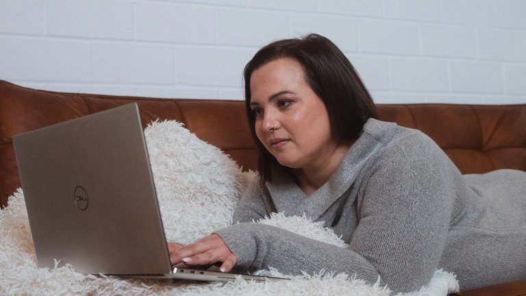 Eine Frau liegt im Bett und checkt ihr Depot