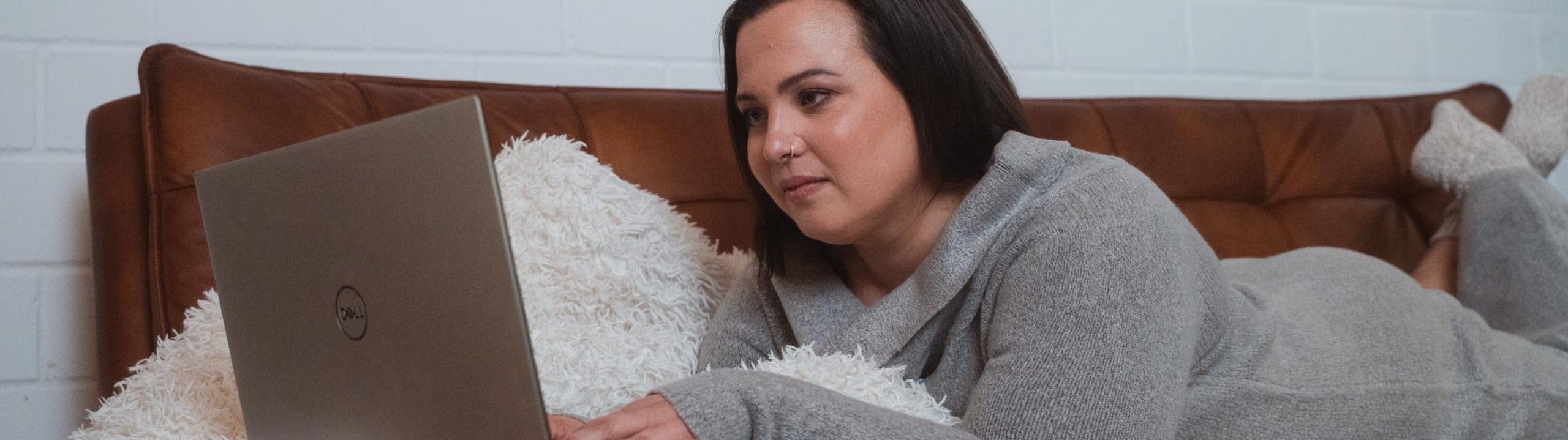 Eine Frau liegt im Bett und checkt ihr Depot