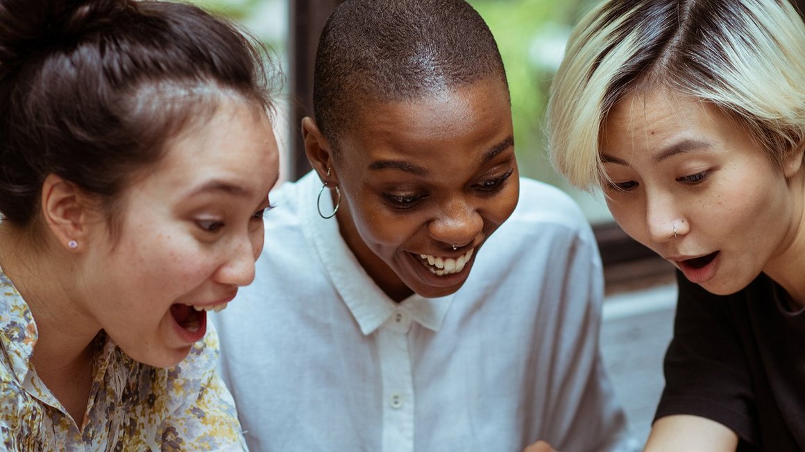 Three women sitting together laughing