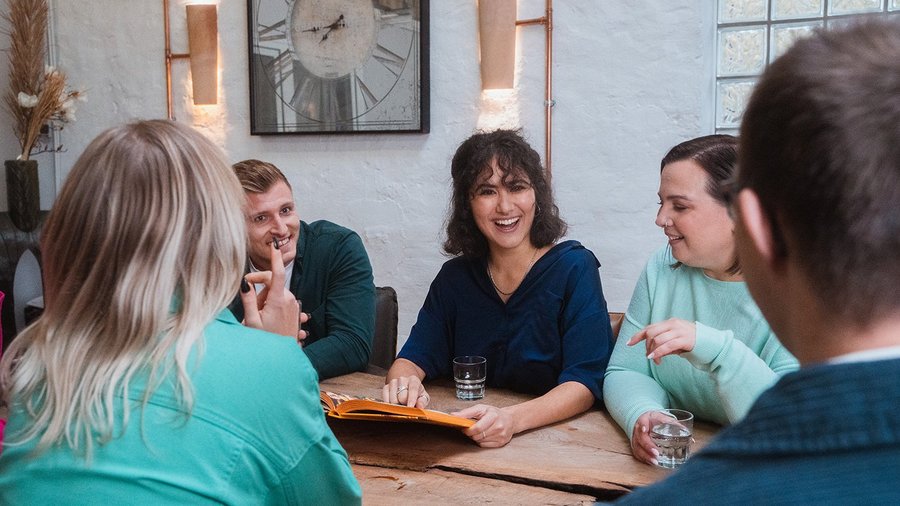 Team sits together in a meeting laughing