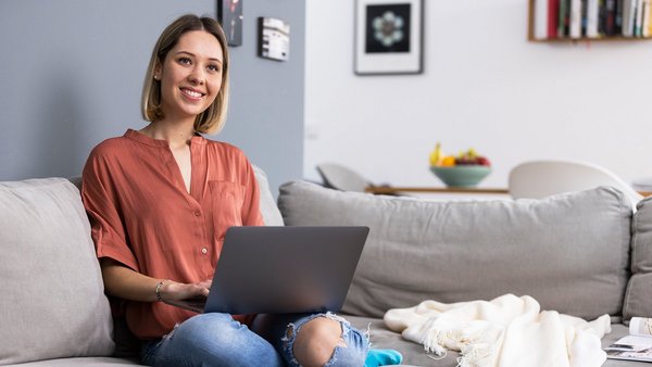 Frau mit Laptop auf der Couch – Work-Life-Integration