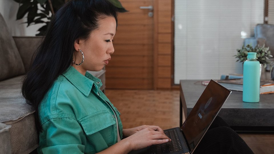 Frau arbeitet konzentriert am Laptop