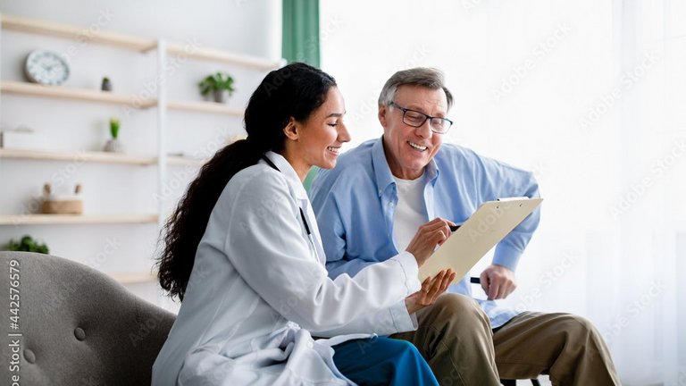 Ärztin erklärt einem älteren Mann etwas auf einem Tablet.