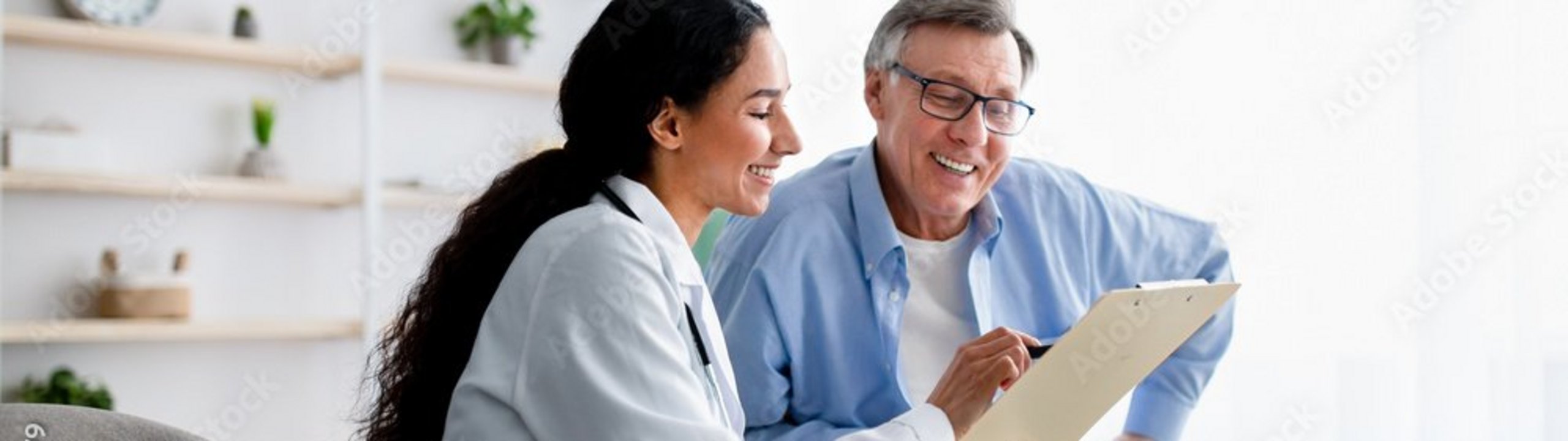 Ärztin erklärt einem älteren Mann etwas auf einem Tablet.