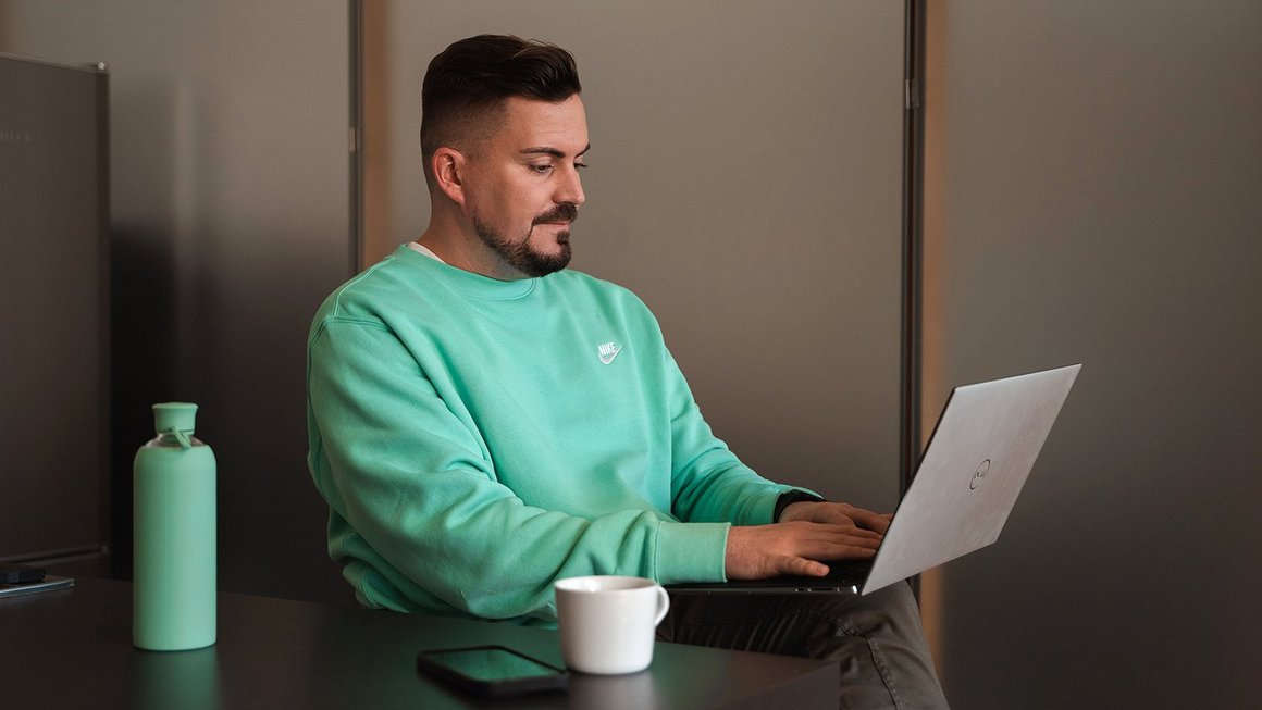 Young father works on laptop when returning to work after parental leave