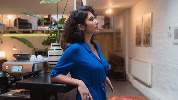 A woman focuses intensely while leaning on a counter