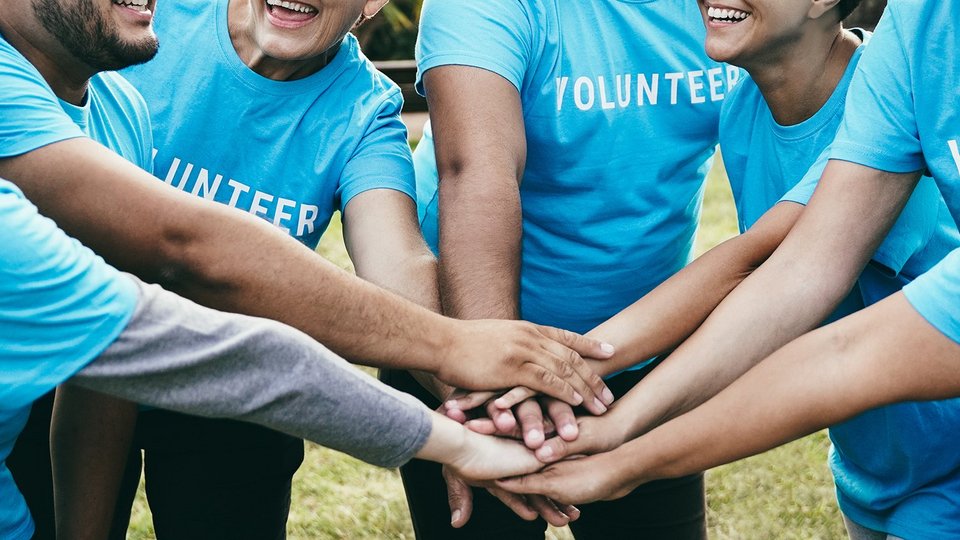Group of volunteers putting their hands together