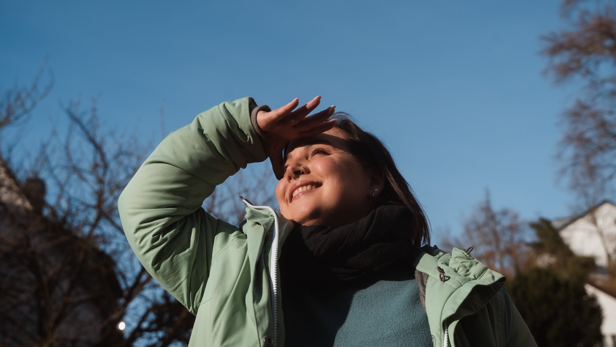 Young Woman standing outside and looks happy and full of hope.