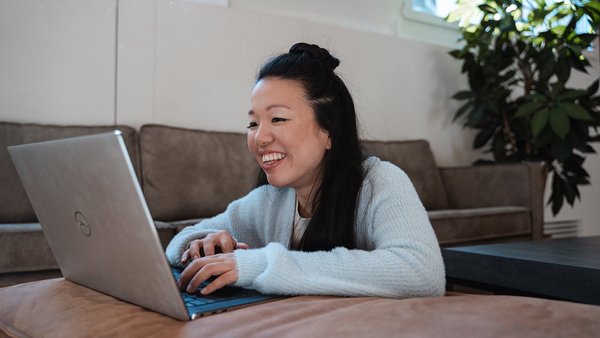 Junge Frau arbeitet motiviert am Laptop
