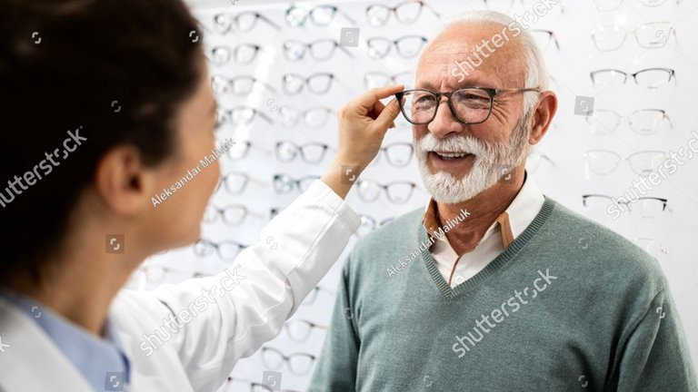 Älterer Herr bekommt vom Optiker eine Brille eingestellt 