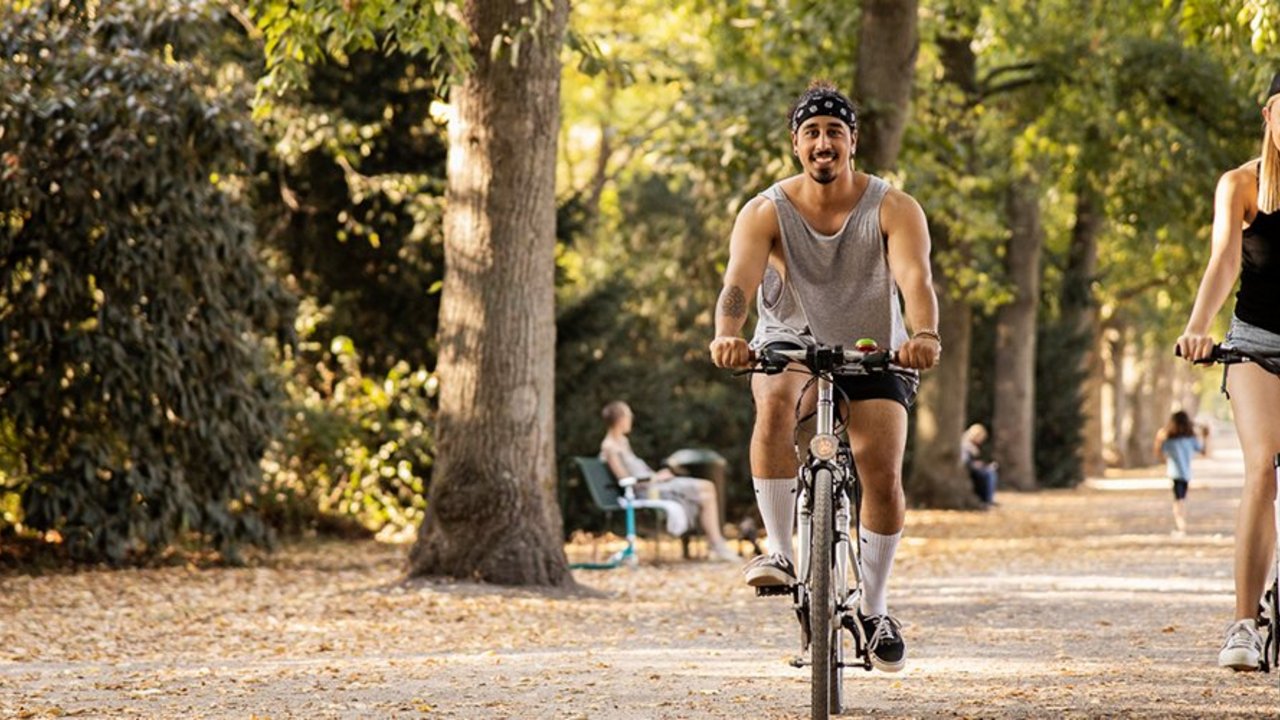 Zwei junge Leute fahren Rad im Park
