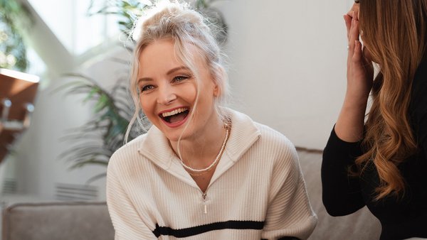 Set personal goals and use them as a source of strength Laughing woman with colleague motivates herself at work