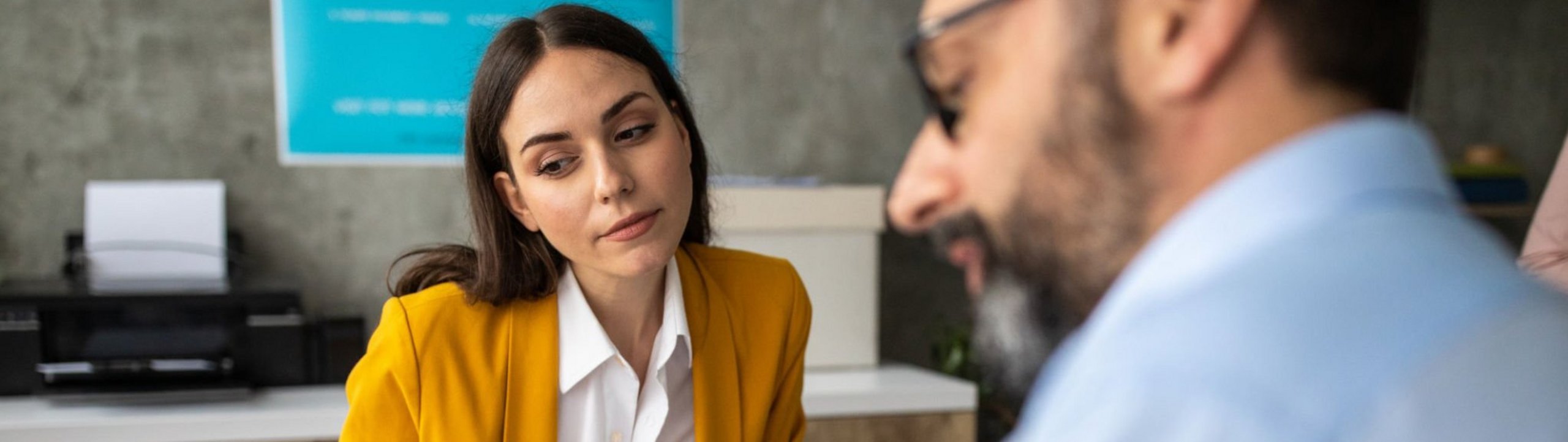 Eine Frau und ein Mann besprechen gemeinsam ein Dokument am Tisch.