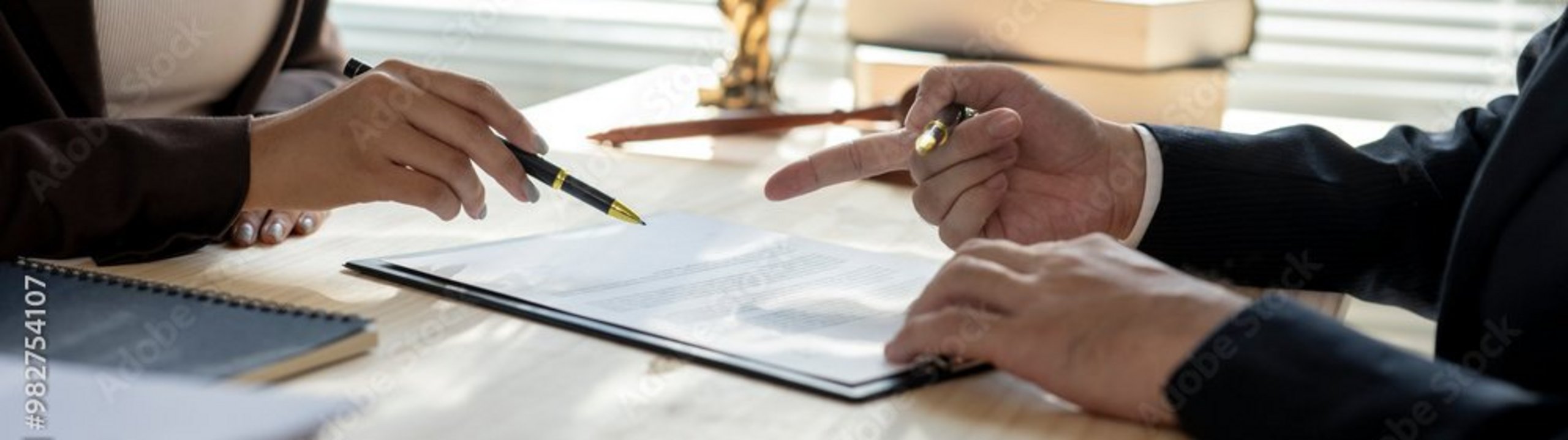 Zwei Personen besprechen ein Dokument am Schreibtisch.