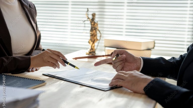 Zwei Personen besprechen ein Dokument am Schreibtisch.