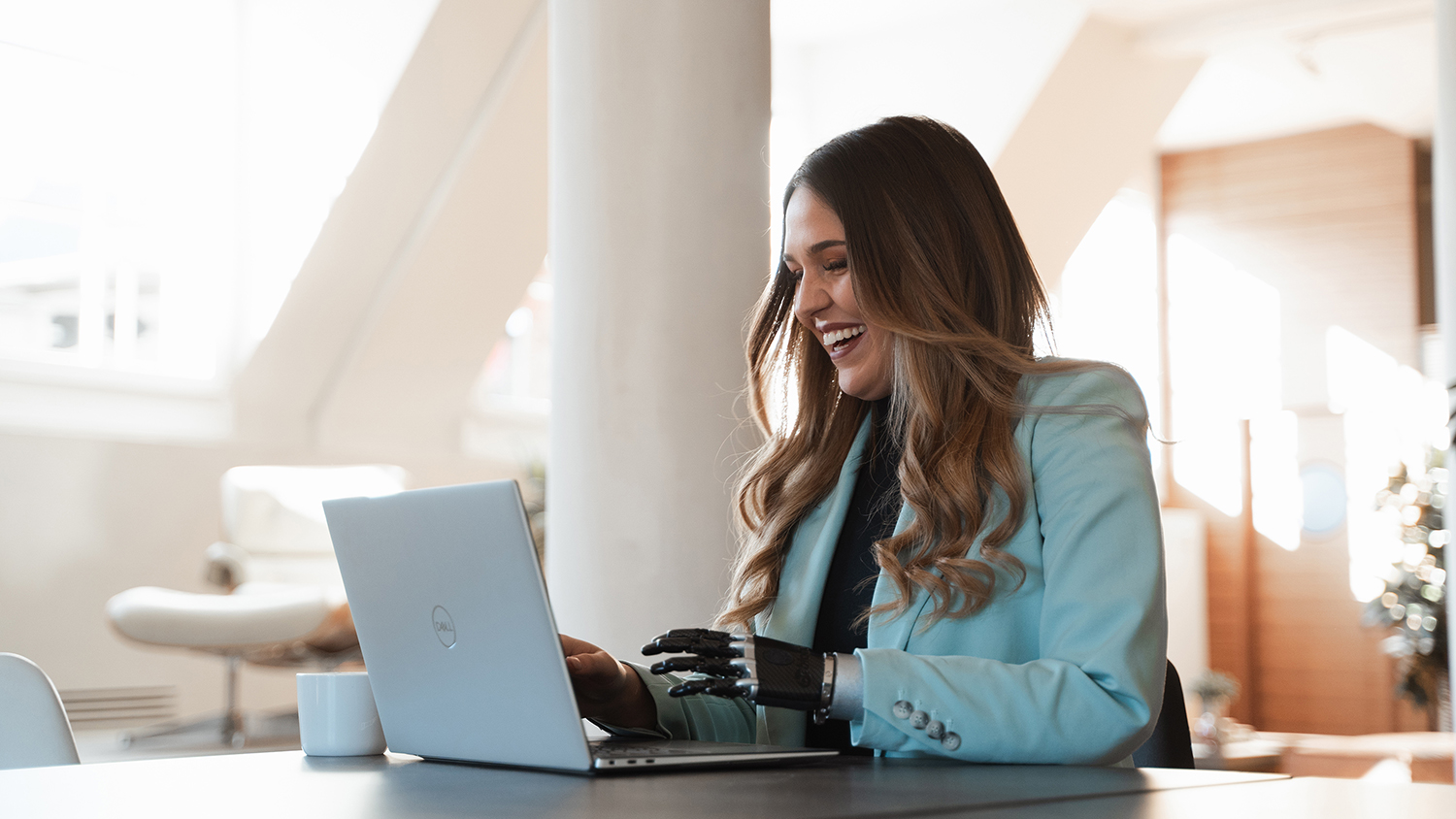 Woman laughing as she works on her laptop
