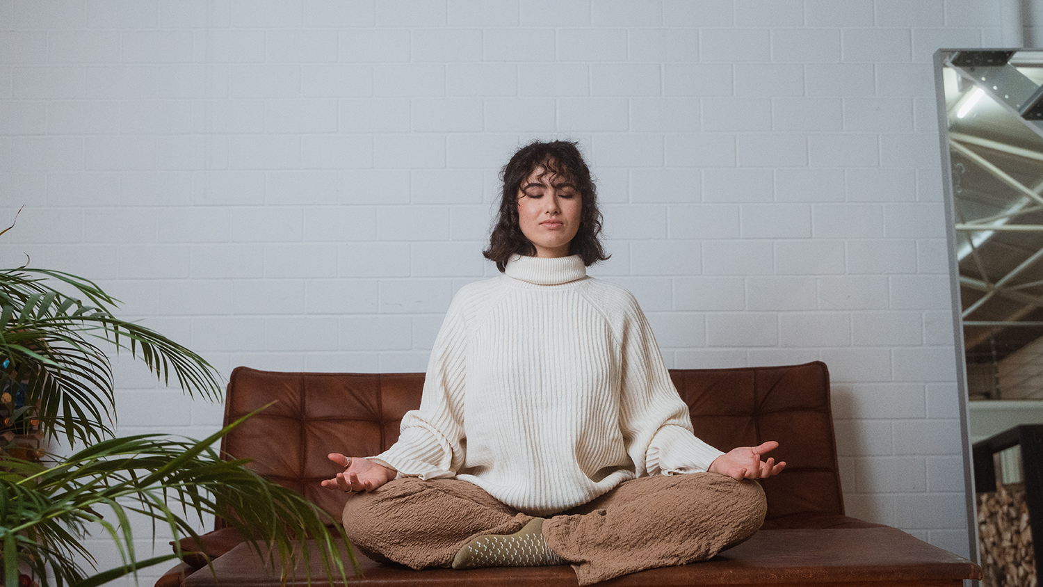 Woman sits on the couch relaxed using good routines