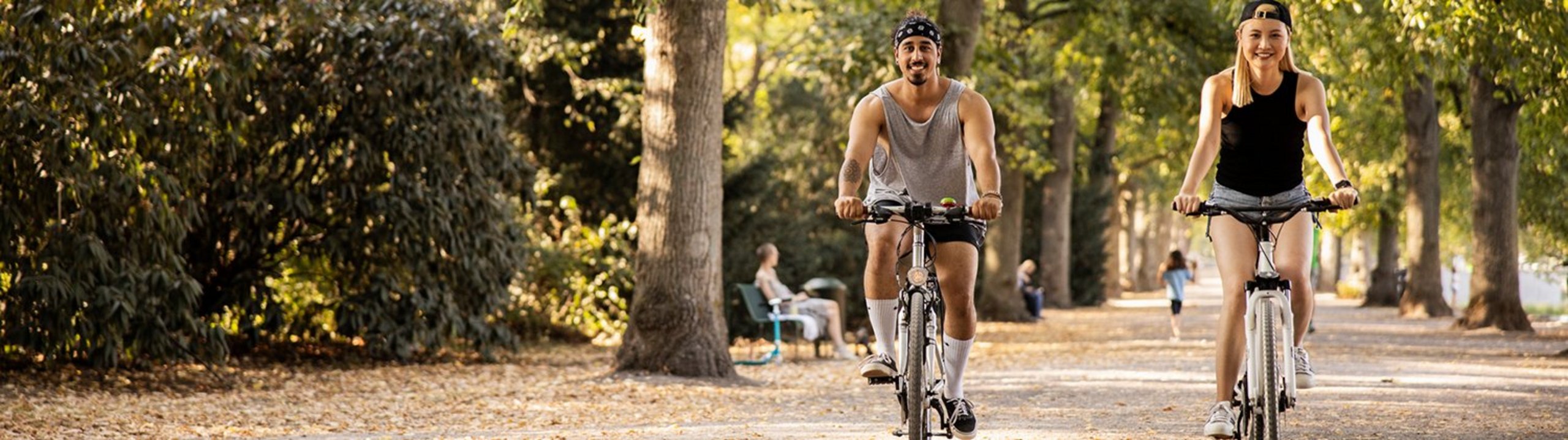 Zwei junge Leute fahren Rad im Park