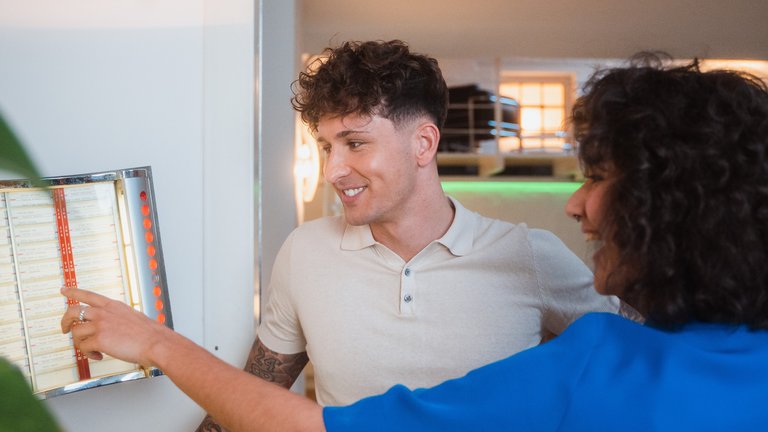 [Translate to English:] Geschäftsmann und Geschäftsfrau mit Tablet im Gespräch