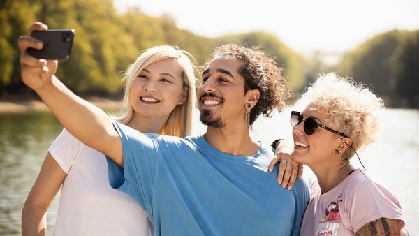 Living in the here and now Three young people take a selfie in the park