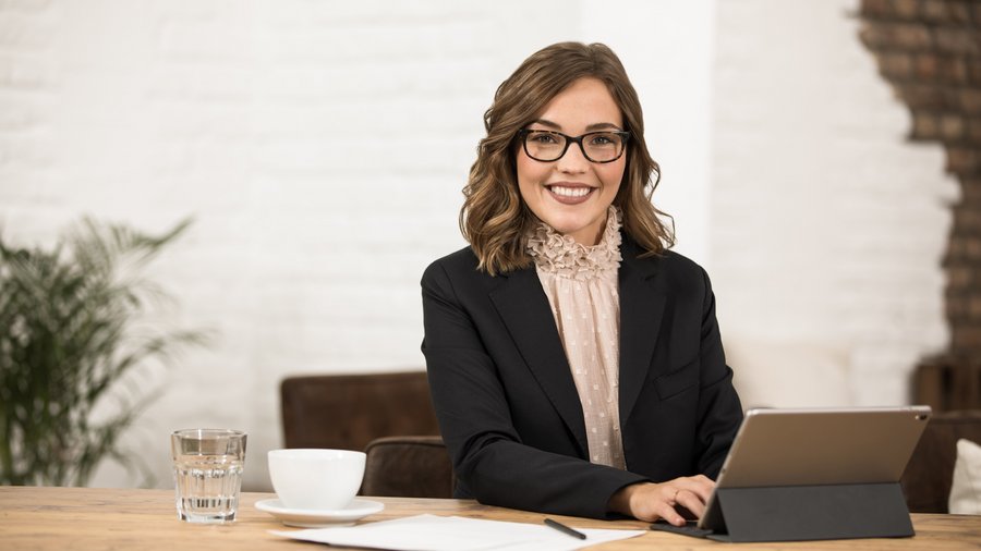 Frau arbeitet am Tablet und lächelt