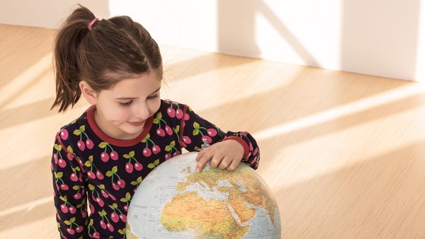 A child looks at a globe