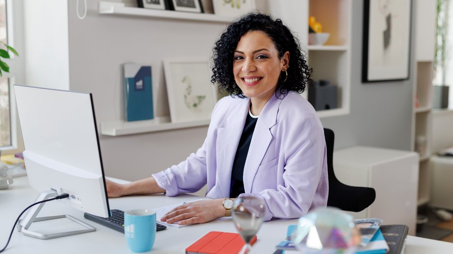 Junge Frau in Jeanshemd schaut auf ihr Smartphone.