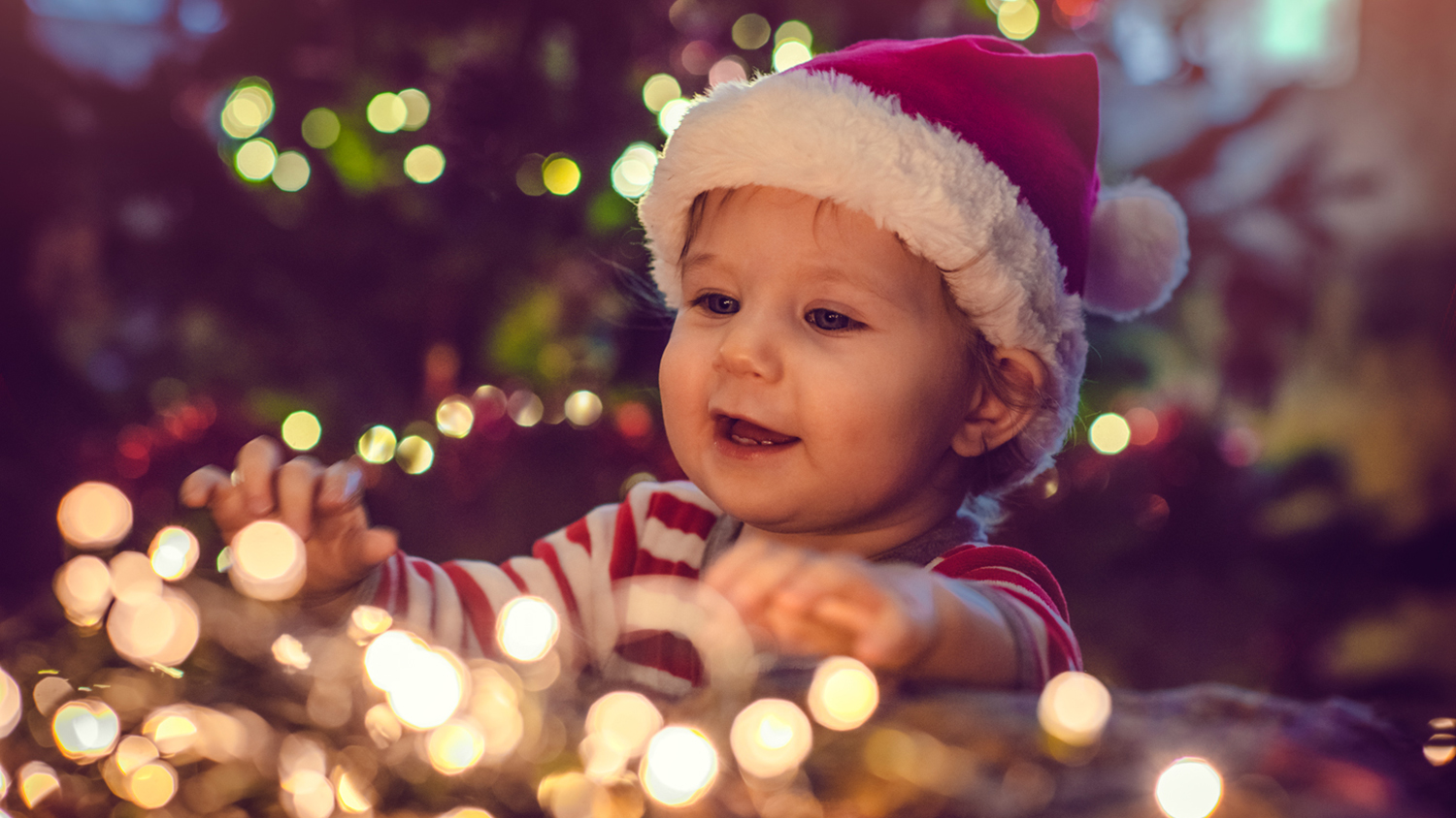 Child with Christmas lights and Christmas hat - Social responsibility and charity Child with Christmas lights and Christmas hat - Social responsibility and charity