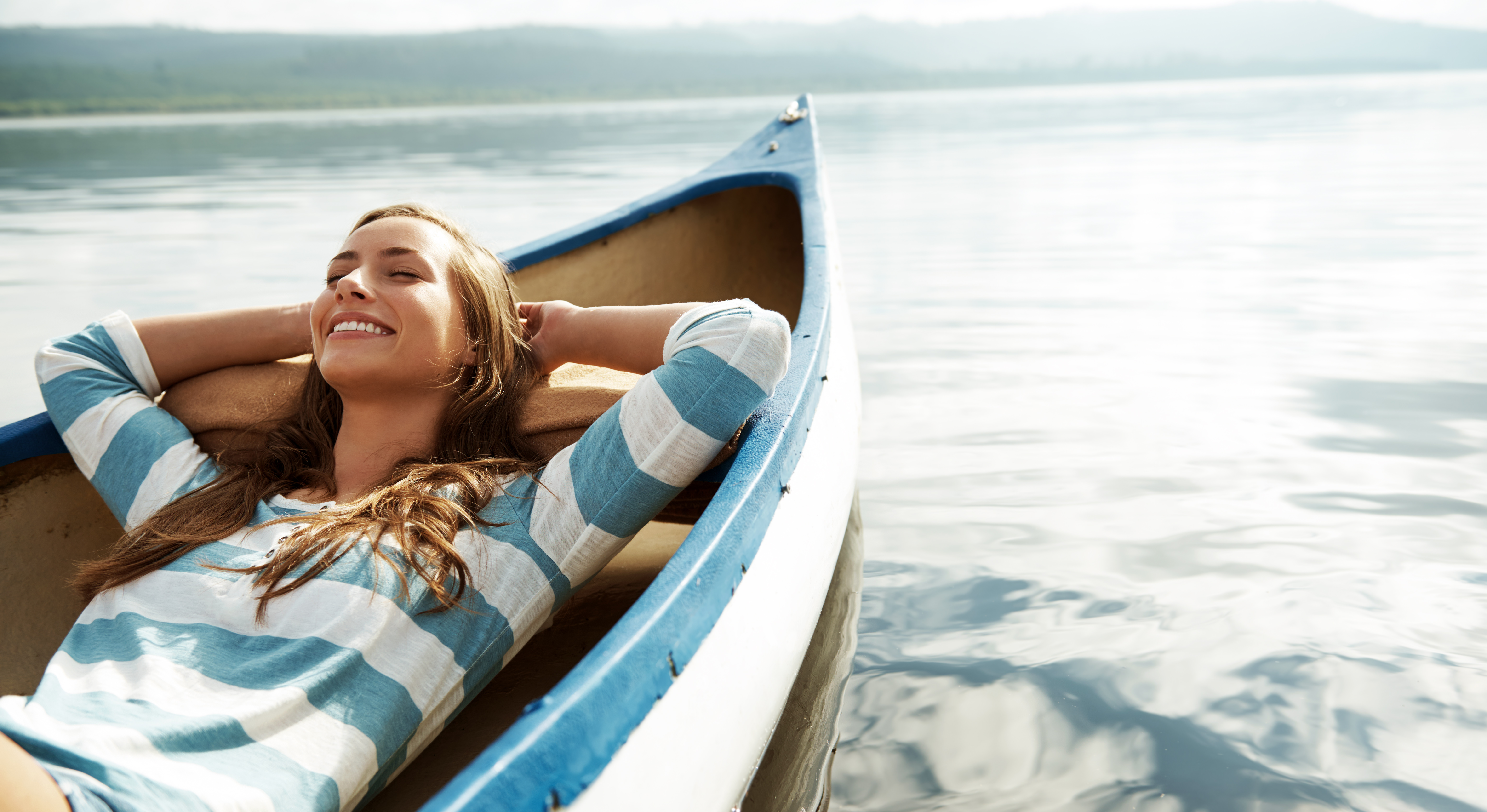pixdeluxe/istockphoto Frau liegt entspannt auf Boot. Trotz Corona entspannt in den Urlaub